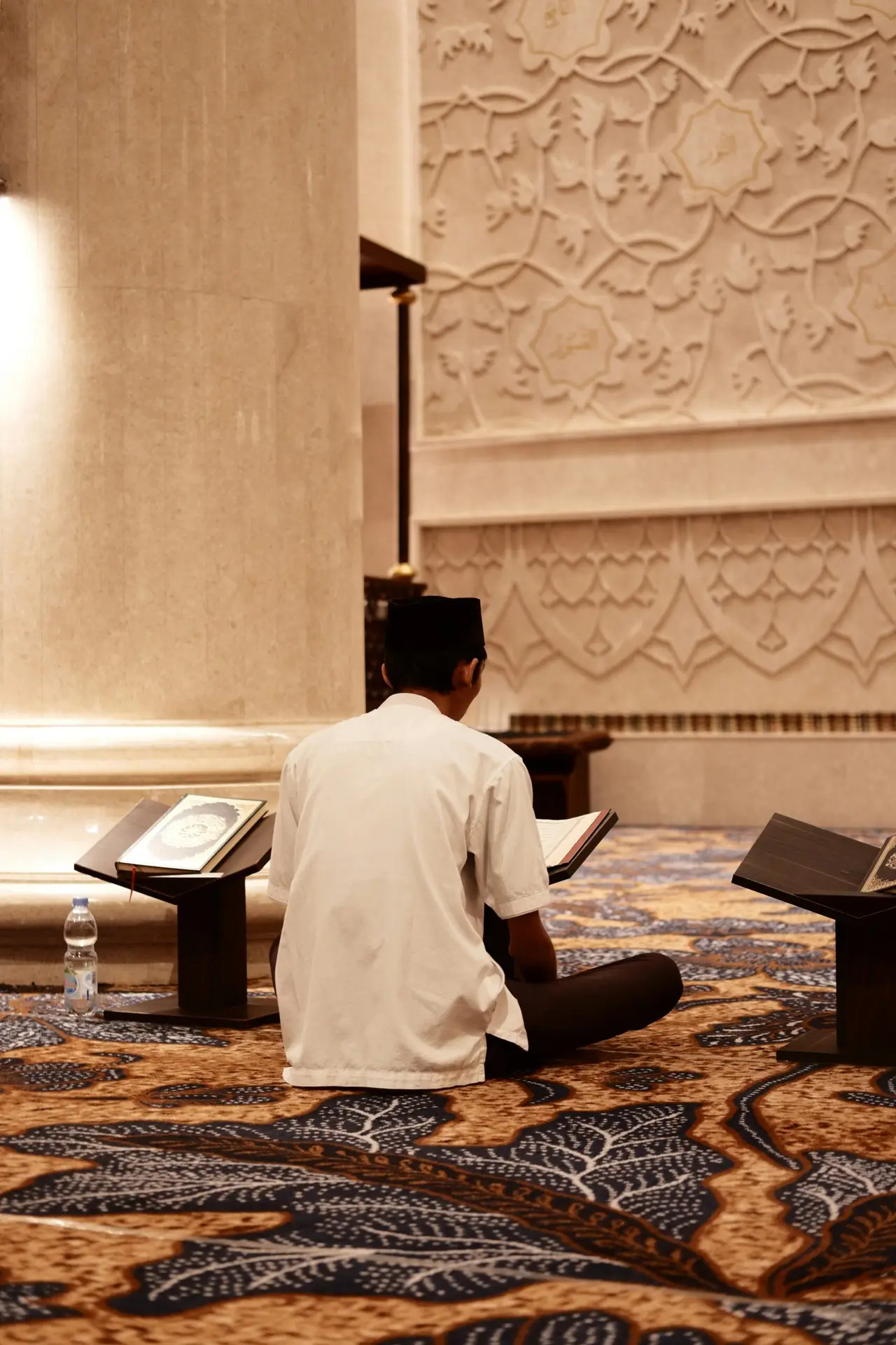 a man sitting on the floor reading a book